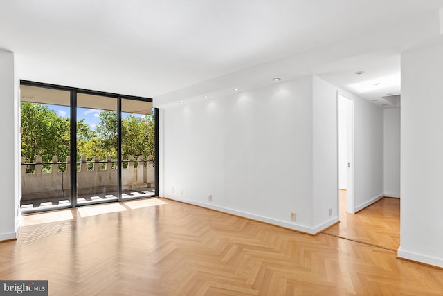 empty room with light parquet flooring and expansive windows