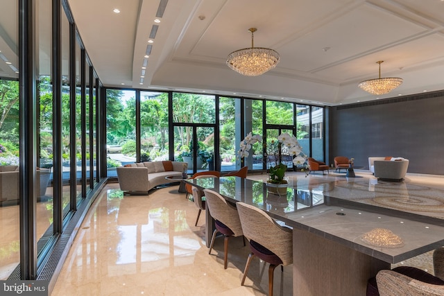 dining area with a chandelier, a raised ceiling, expansive windows, and light tile floors