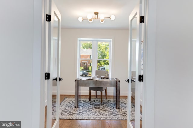 office space with french doors, baseboards, and wood finished floors