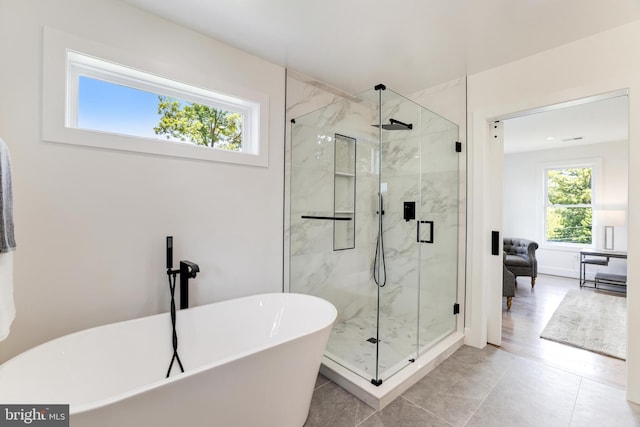 bathroom with a soaking tub and a marble finish shower