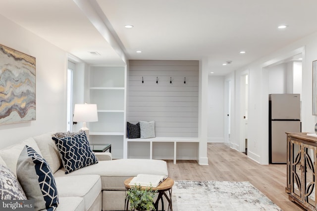 living room featuring light wood-type flooring, baseboards, and recessed lighting