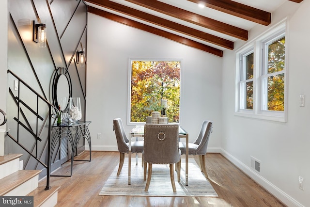 dining space featuring lofted ceiling with beams, light wood finished floors, stairs, and visible vents