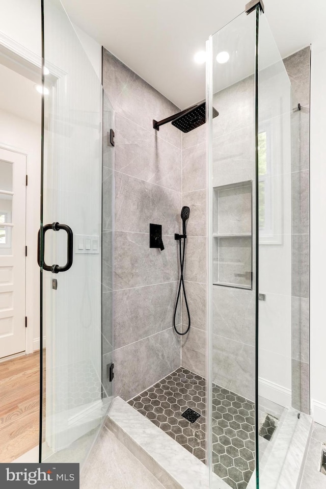 full bathroom with a shower stall and wood finished floors