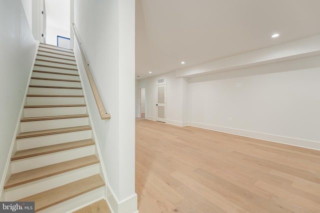 staircase featuring baseboards, wood finished floors, and recessed lighting