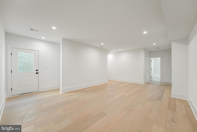 empty room with light wood-type flooring, visible vents, and recessed lighting