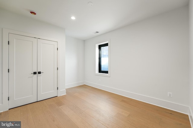 unfurnished bedroom with light wood finished floors, recessed lighting, a closet, visible vents, and baseboards