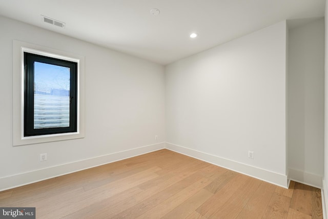 spare room featuring visible vents, light wood-style flooring, and baseboards