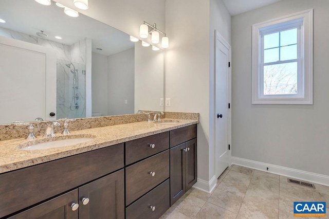 bathroom featuring walk in shower, double sink vanity, and tile flooring