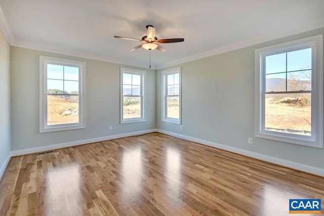 spare room featuring ceiling fan, crown molding, and light hardwood / wood-style floors