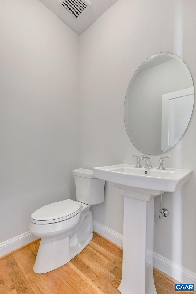 bathroom with hardwood / wood-style floors and toilet