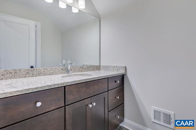 bathroom featuring vaulted ceiling and vanity