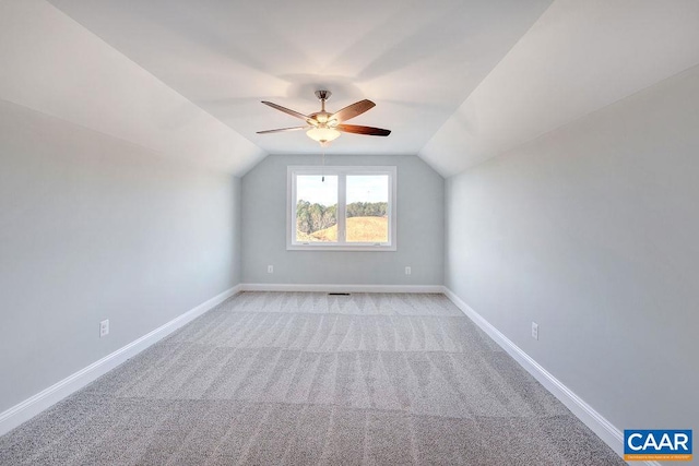 additional living space with ceiling fan, light colored carpet, and vaulted ceiling