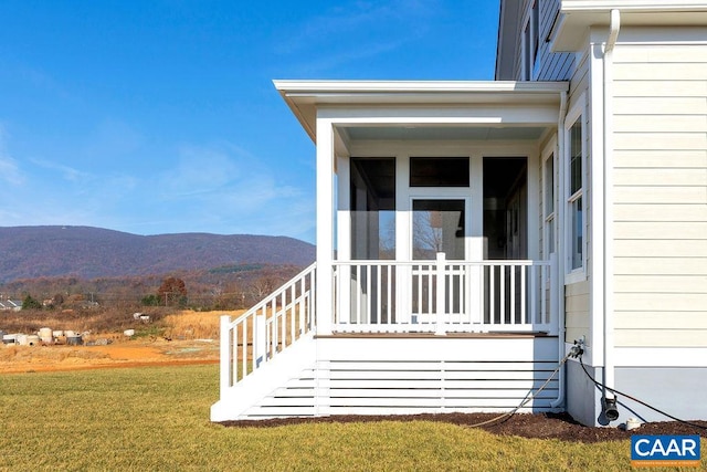 doorway to property featuring a lawn and a mountain view