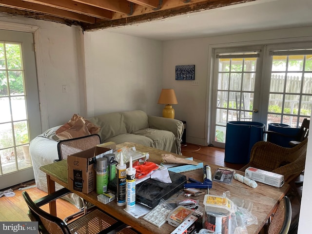 living room with beam ceiling, wood-type flooring, french doors, and a wealth of natural light