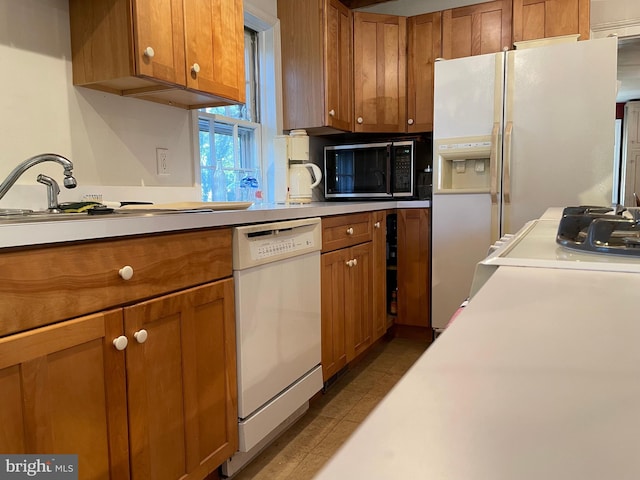 kitchen with white appliances, sink, and tile floors