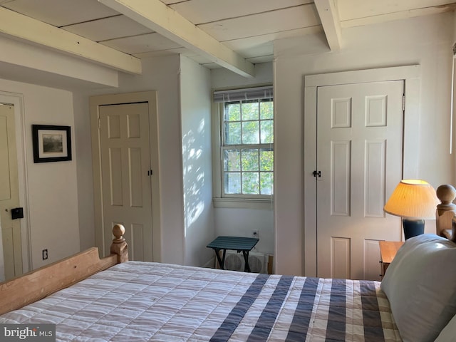 bedroom with beamed ceiling and a closet