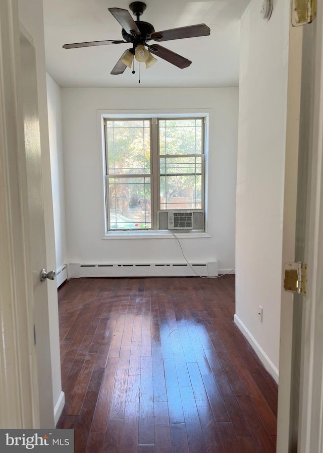 empty room featuring ceiling fan, baseboard heating, and dark hardwood / wood-style floors