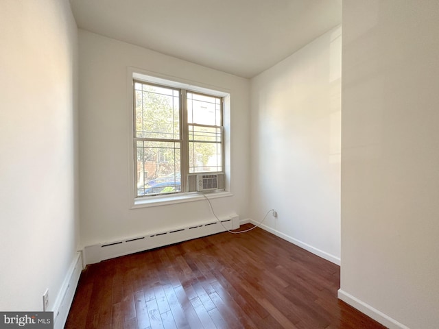 unfurnished room with a baseboard radiator, a wealth of natural light, and dark hardwood / wood-style flooring