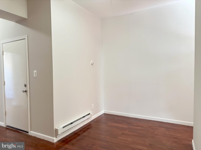 unfurnished room featuring baseboard heating and dark hardwood / wood-style floors