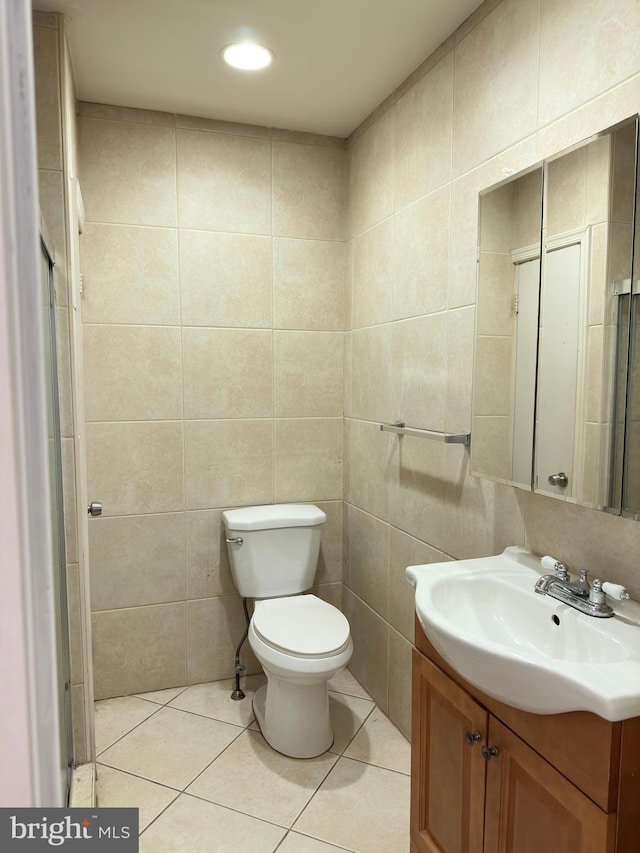 bathroom with tile walls, tile floors, toilet, and vanity