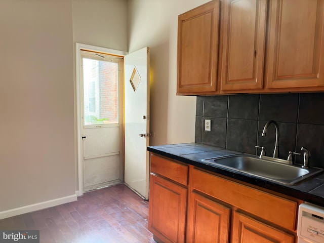 kitchen featuring backsplash, dishwashing machine, hardwood / wood-style floors, and sink