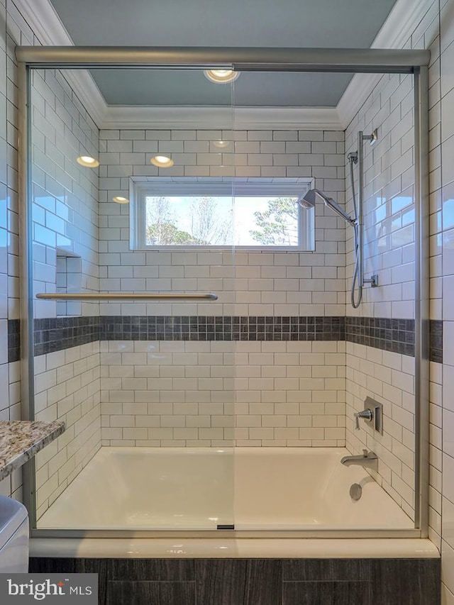 bathroom featuring ornamental molding, a healthy amount of sunlight, and enclosed tub / shower combo