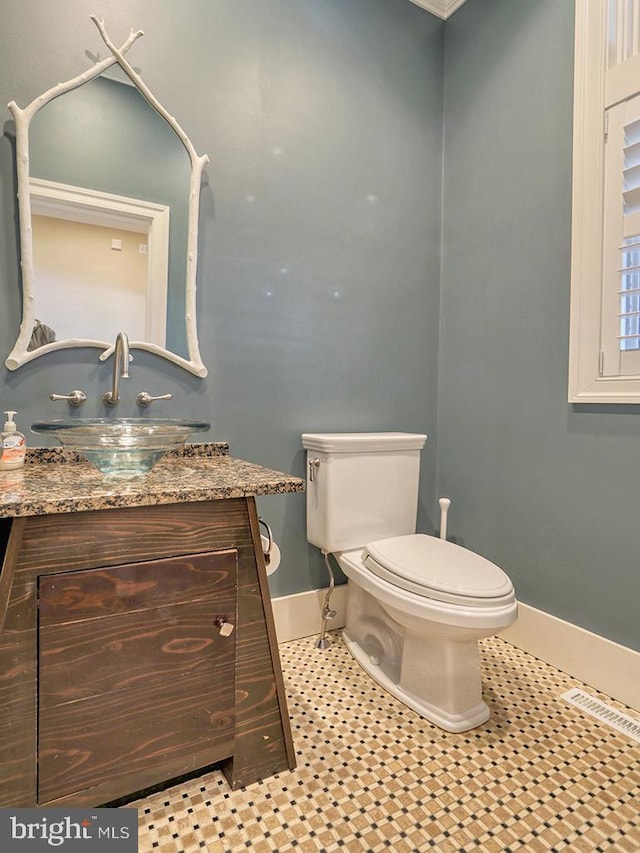 bathroom with tile floors, vanity, and toilet