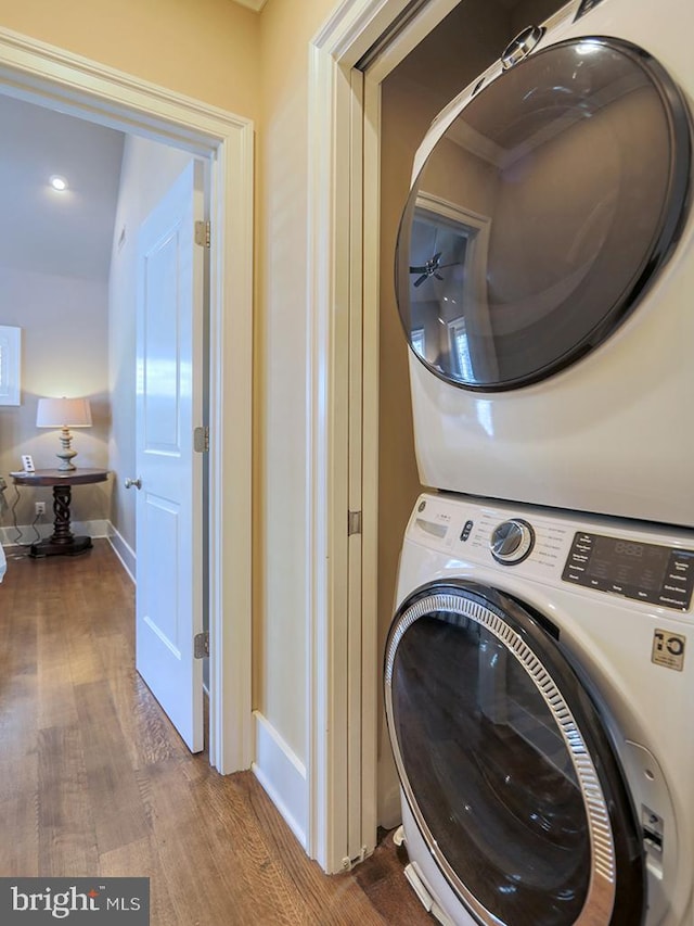 washroom featuring stacked washer and dryer and dark hardwood / wood-style floors