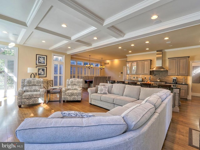 living room featuring beamed ceiling, crown molding, a chandelier, hardwood / wood-style flooring, and coffered ceiling