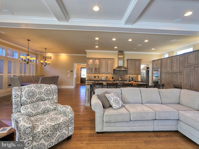 living room featuring a chandelier, crown molding, dark hardwood / wood-style flooring, and beam ceiling