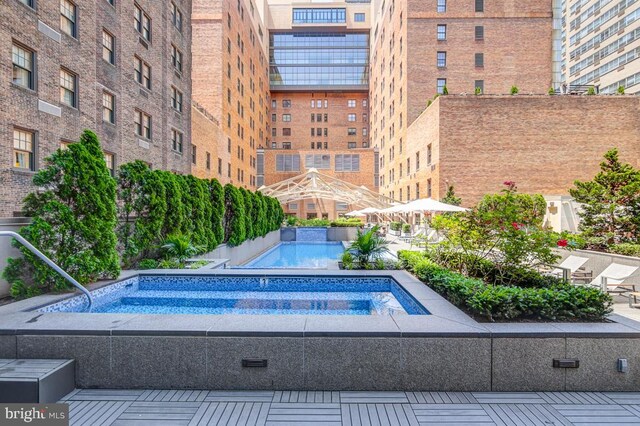 view of swimming pool with a hot tub