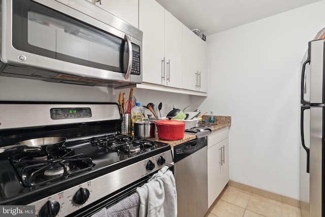 kitchen with stainless steel appliances, light tile floors, and white cabinetry