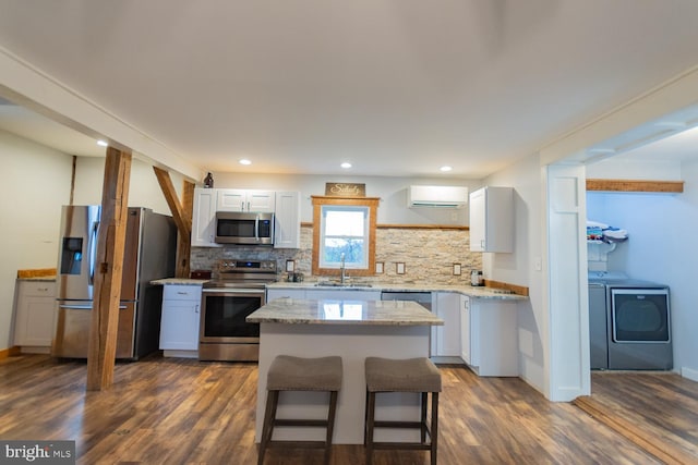 kitchen featuring sink, dark hardwood / wood-style floors, washing machine and dryer, and stainless steel appliances