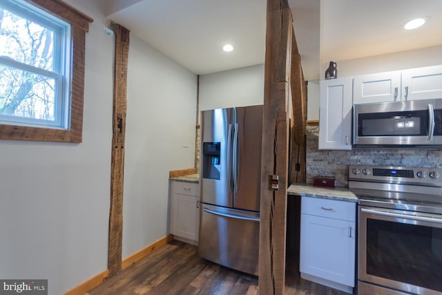 kitchen featuring white cabinets, dark hardwood / wood-style floors, decorative backsplash, appliances with stainless steel finishes, and light stone counters