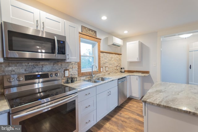 kitchen featuring sink, stainless steel appliances, decorative backsplash, white cabinets, and light wood-type flooring