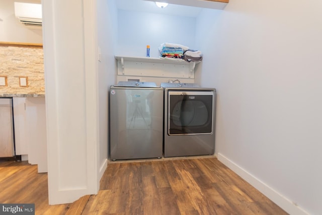 clothes washing area featuring a wall mounted air conditioner, dark hardwood / wood-style floors, and separate washer and dryer