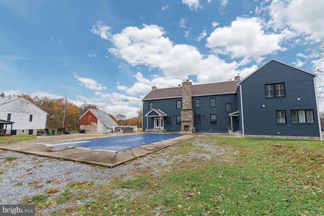 view of pool featuring a lawn, a diving board, and a patio area