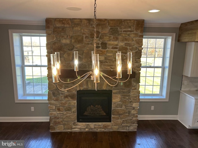 interior details with a stone fireplace, crown molding, and hardwood / wood-style flooring