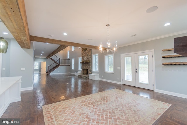 entrance foyer with french doors, ornamental molding, an inviting chandelier, beamed ceiling, and dark hardwood / wood-style floors