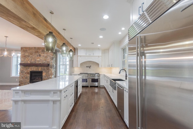 kitchen featuring white cabinets, dark wood-type flooring, a center island, and stainless steel appliances