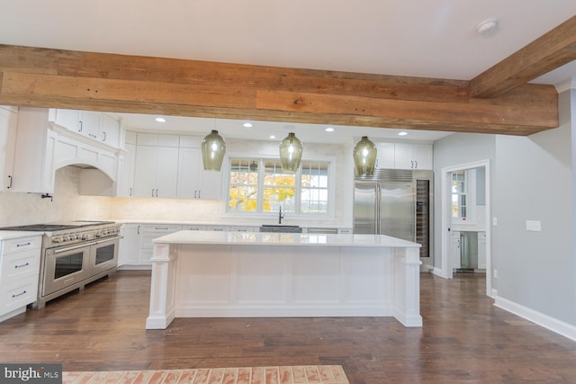 kitchen featuring premium appliances, a kitchen island, dark hardwood / wood-style floors, and beam ceiling