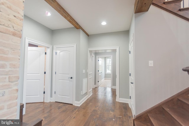 entrance foyer featuring beamed ceiling and dark hardwood / wood-style flooring