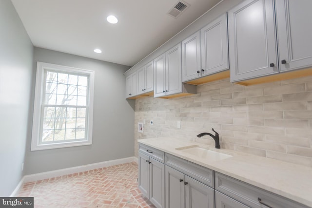 clothes washing area featuring sink, cabinets, and washer hookup