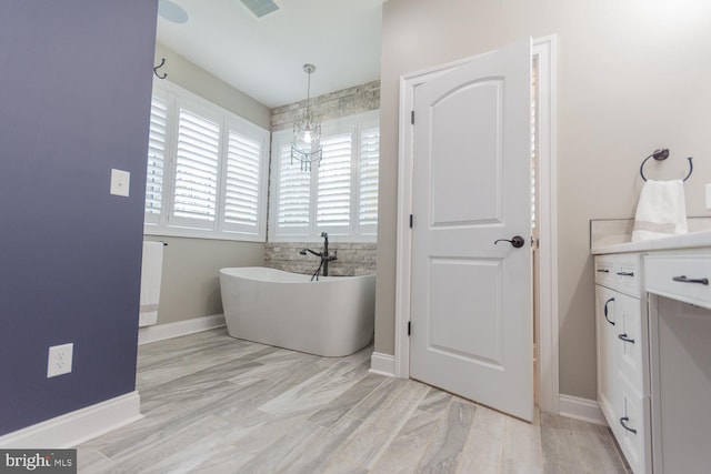 bathroom featuring a bathtub, vanity, a chandelier, and hardwood / wood-style flooring