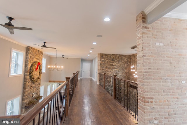 hall featuring hardwood / wood-style flooring, crown molding, and an inviting chandelier