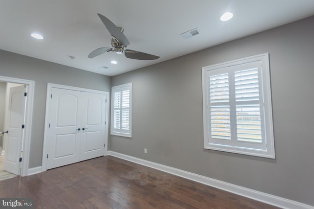 unfurnished bedroom featuring dark hardwood / wood-style flooring, a closet, and ceiling fan