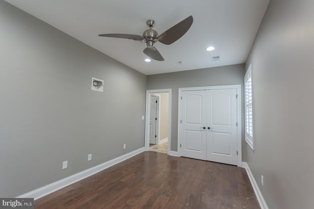unfurnished bedroom with a closet, ceiling fan, and dark hardwood / wood-style flooring