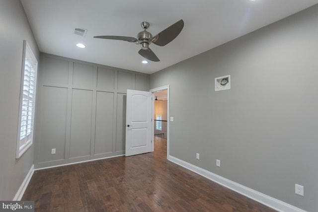 unfurnished bedroom with multiple windows, ceiling fan, and dark hardwood / wood-style flooring