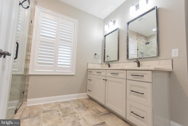 bathroom featuring vanity, a healthy amount of sunlight, and a shower with shower door