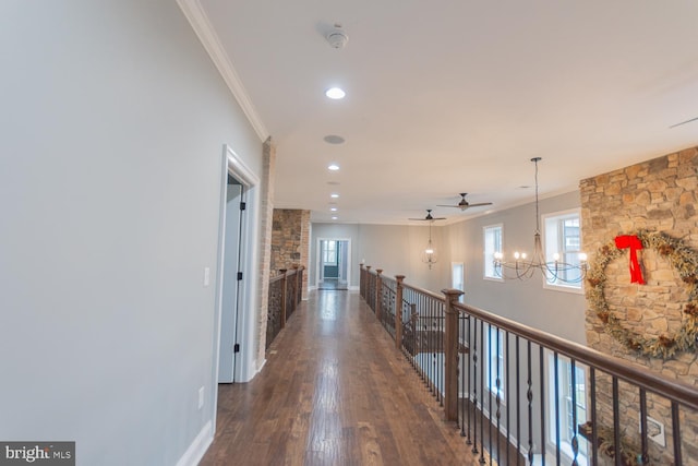 hallway featuring crown molding, dark hardwood / wood-style flooring, and a notable chandelier